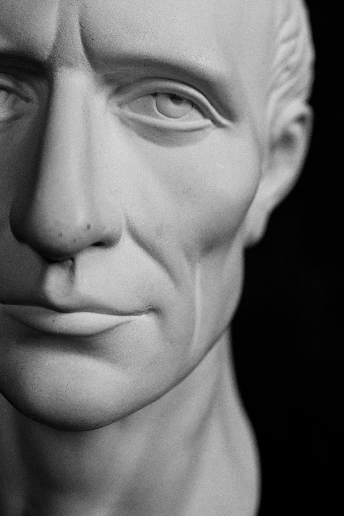 Buste en plâtre d'un visage d'homme sur fond noir