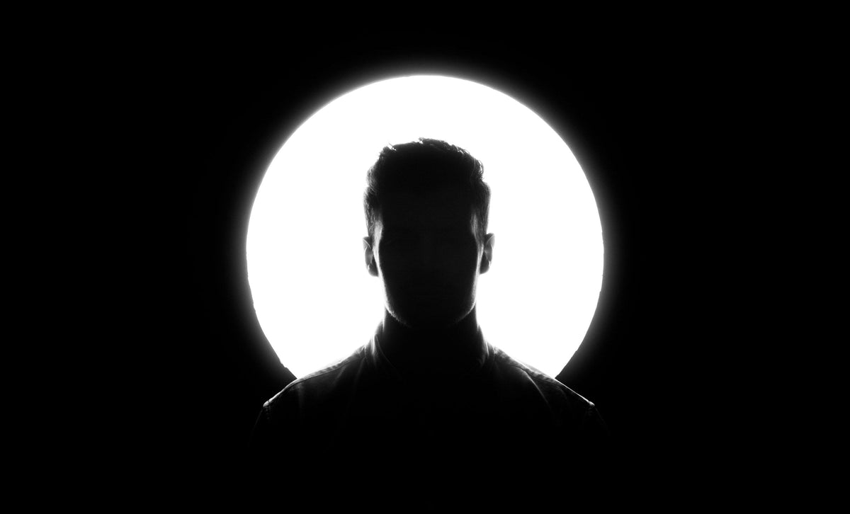 Silhouette d'homme devant un cercle de lumière